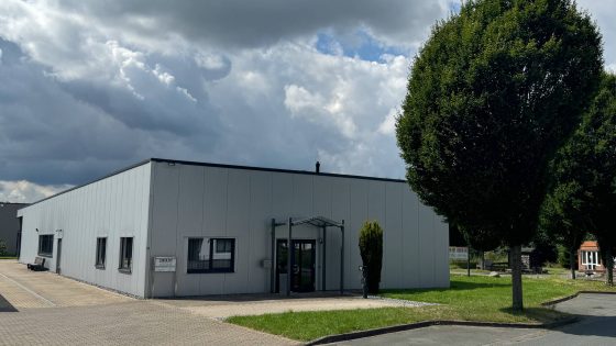 Frontansicht des Firmengebäudes von RATIO-CUT mit moderner Architektur und grünem Umfeld.