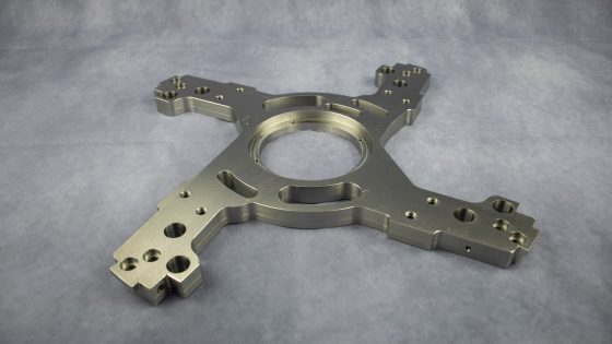 CNC-Bauteil mit komplexen Konturen und mehreren Bohrungen.